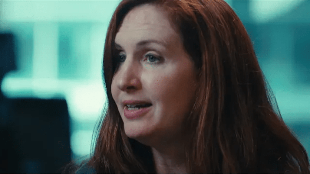 Woman with red hair looking off to the left during an interview