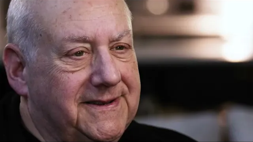 White man's face with blurred background during an interview