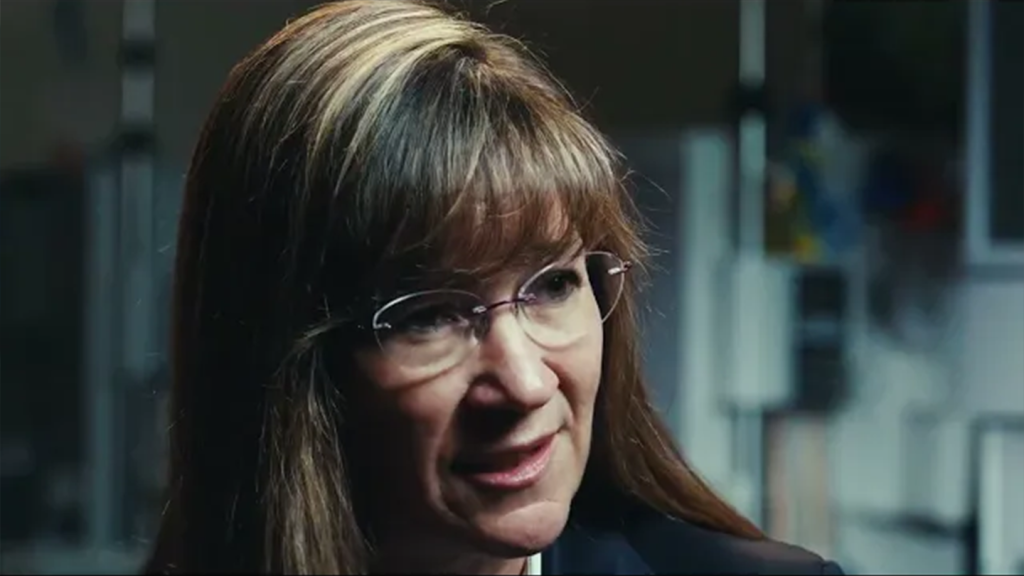 Woman with glasses looking to her left during an interview
